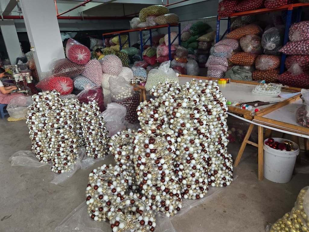 Christmas ornament warehouse with stacked wreath frames and bulk inventory bags ready for export programs