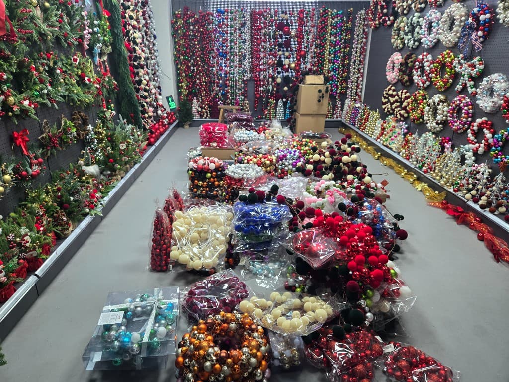 Christmas ornament OEM showroom with wreath, garland, and bauble programs staged for wholesale buyer review