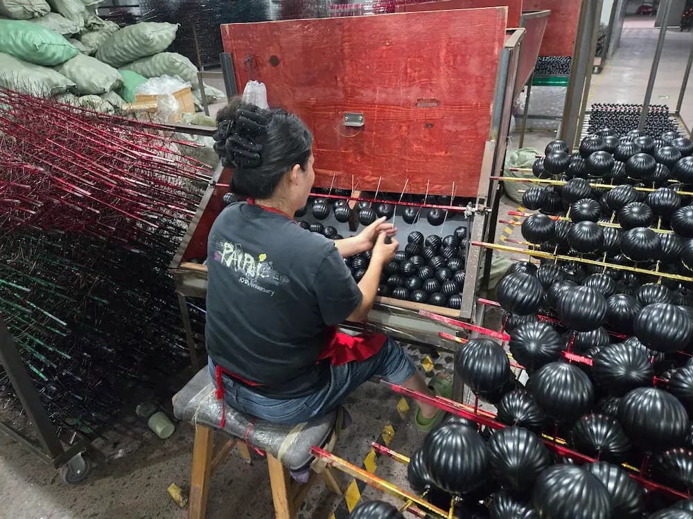 Hand decoration at a Christmas ornament factory for mass-retail supplier programs