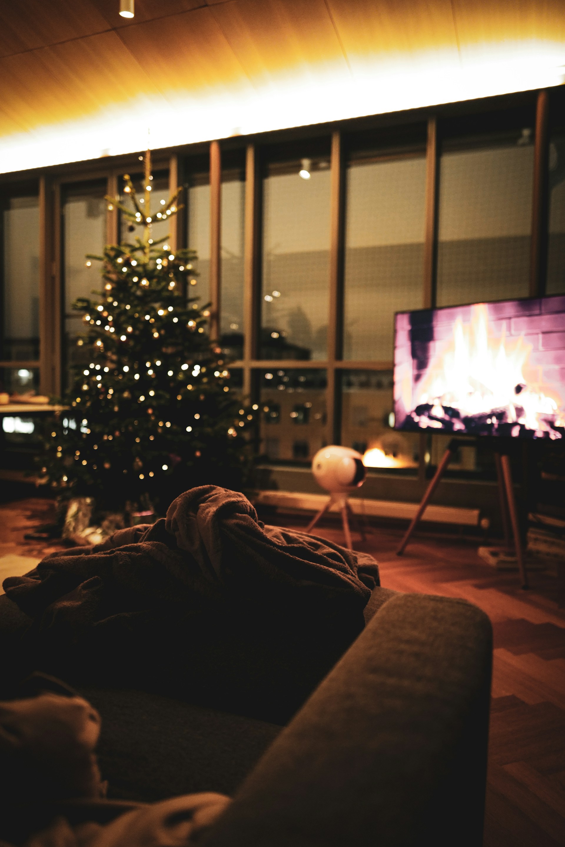 Premium artificial Christmas tree with warm lights and coordinated ornaments in a modern living room display