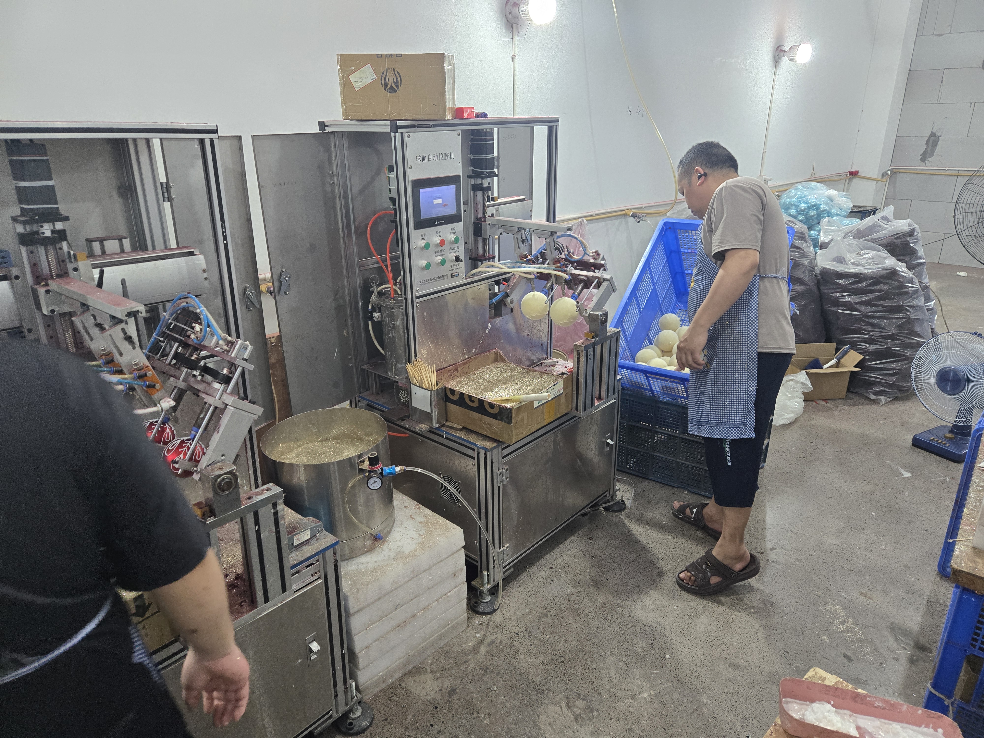 Workers hand-assembling and finishing Christmas ball ornaments at craft stations